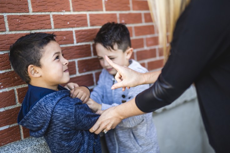Teacher Stopping Two Boys Fighting In Playground